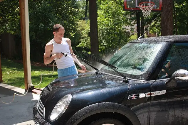 Man rinsing mini-cooper car