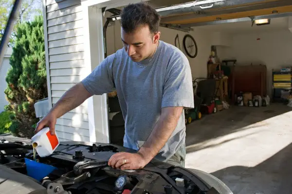 man changing car engine oil