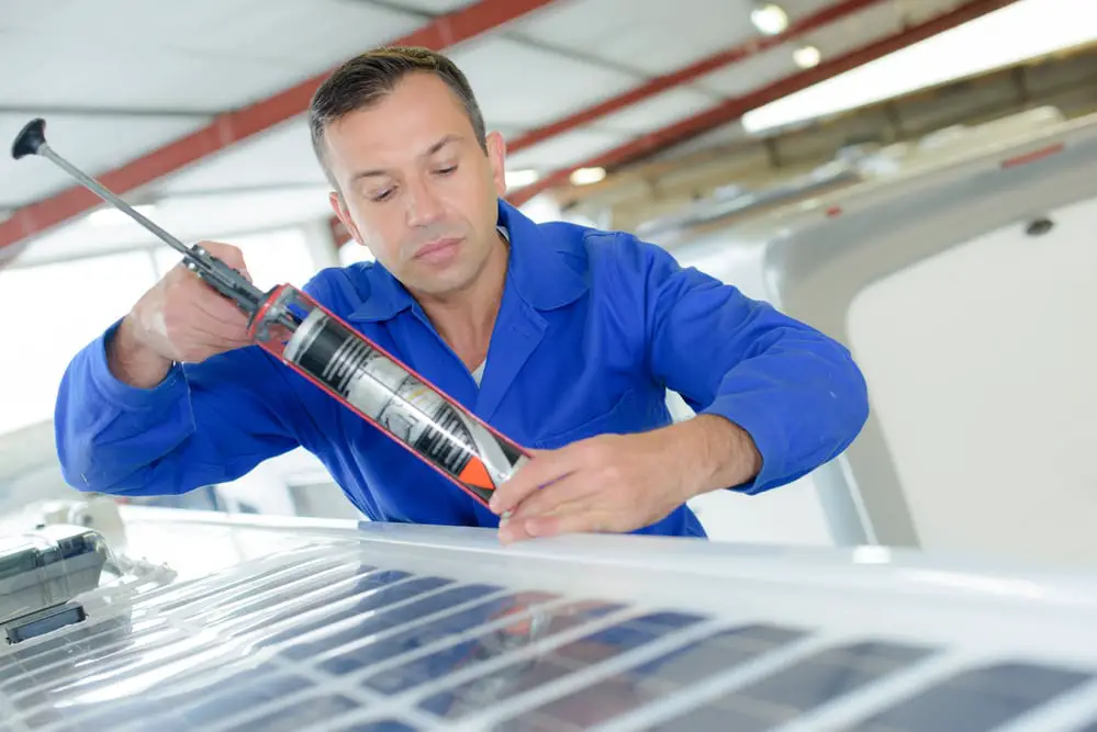 man sealing rv roof