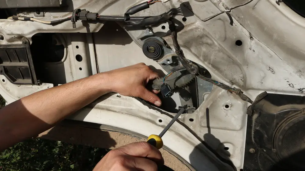 mechanic replacing a window regulator